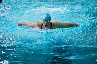 girl swimmer swims butterfly in pool