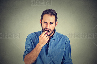 disgusted man with finger in mouth displeased with situation ready to throw up