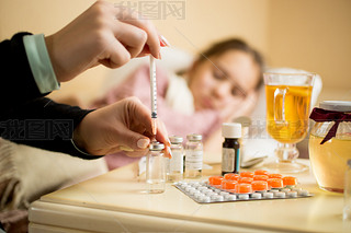 Macro shot of woman filling syringe from ampule