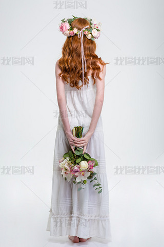 Back view of woman in wreath standing and hiding bouquet 