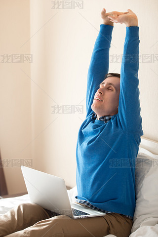 Young man stretching after working on computer