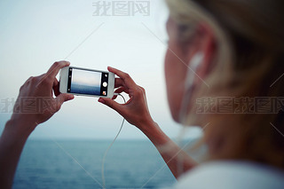 woman shoots video of sea landscape