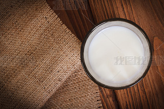 Milk in a glass on a wooden table top view