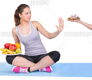 girl on a sports carpet chooses fruit instead of sweets