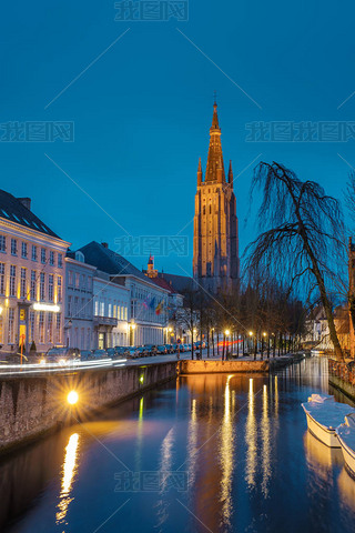 Evening on the streets of Bruges after rain. View of the night Onze Lieve. Brugge against the backgr