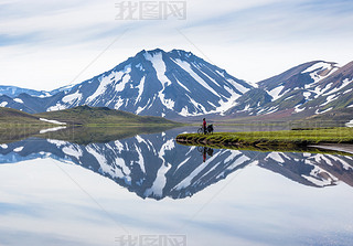 biker on backdrop of lake and mountains