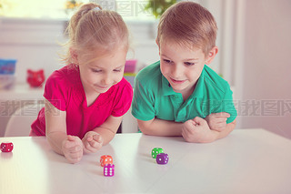 Two happy children playing with dices