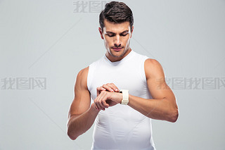 Handsome fitness man using art watch