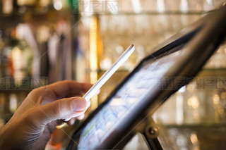 Man paying with NFC technology on mobile phone, in restaurant, b