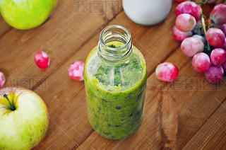 Fresh homemade oothie with kiwi, bananas, grapes, apple on wooden table