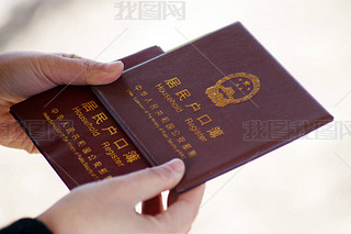 --FILE--A local Chinese resident shows his household register, also known as hukou, in Ji'nan city, 