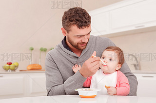 Nice daddy feeding his child 