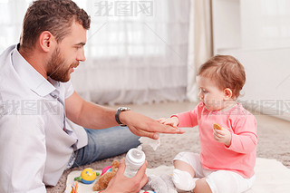 Nice father feeding his baby 