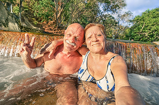 Senior happy couple taking selfie at Maquinit Hot Spring in Coron - Relax concept to Philippines won