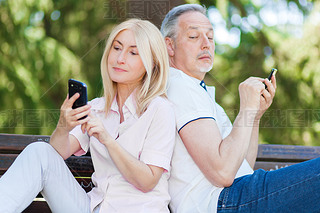 Mature couple using phones