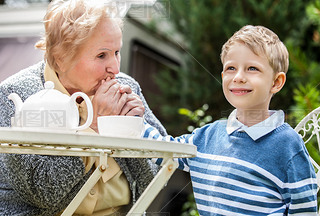 Positive grandmother and grandson spent time together in summer solar garden.