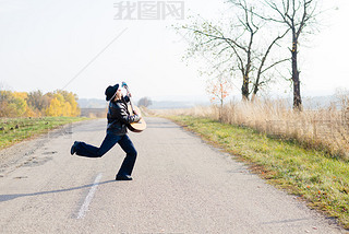 guitarist playing guitar crossing road