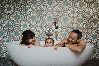 happy family with little daughter in bathtub