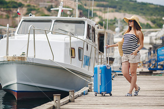 Pregnant beautiful woman on the pier at the sea