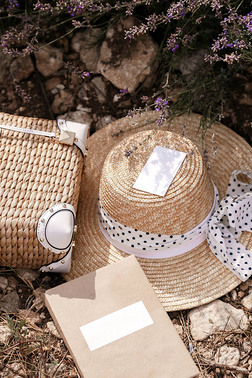 时尚户外照片的纸笔记本, 稻草配件, 豪华草帽和袋躺在 groung 在薰衣草领域