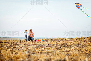 Fother and son flying kite on the field