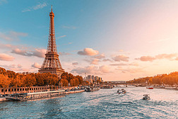 巴黎和整个欧洲的主要景点是埃菲尔铁塔，在塞纳河畔的夕阳下，有游轮旅游船