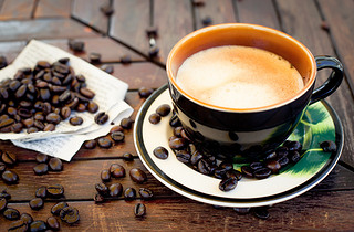 Cup of coffee, cappuccino with beans and a book.