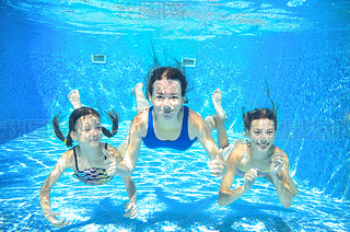 Family swim in pool underwater, happy active mother and children he fun under water, kids sport on
