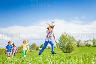 Boy with kids runs with airplane toy