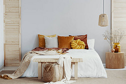 特大号床前的木制长椅，有枕头和毛毯，复制空墙上的空间