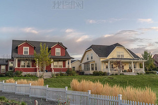 White picket fence with ornamental reeds near sunset