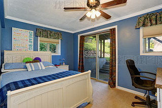 White carved wooden double bed in blue bedroom