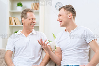 Father and adult son sitting on the sofa