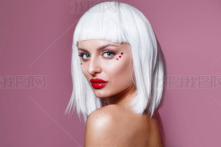 Beauty fashion model girl creative art makeup with red hearts and white hair on pink background