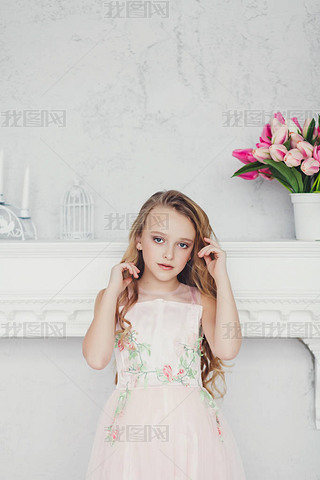 Beautiful little girl with long blond hair standing near wearing dress