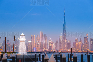 Illuminated decorative lighthouse at the background of famous Burj Khalifa skyscraper tower in the D