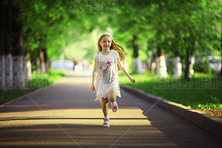 Little girl running in summer park
