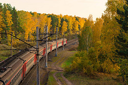 从上面看火车.一列经过的火车轮流开着.秋天的风景铁路。黄色的树电气火车。美丽的风景.