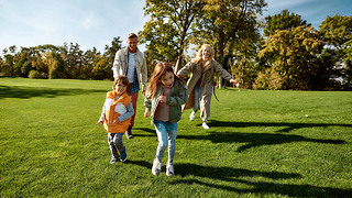 Sunny day. Excited family running outdoors on a sunny day