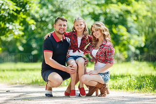 Happy family on a walk in a green Park in the summer.