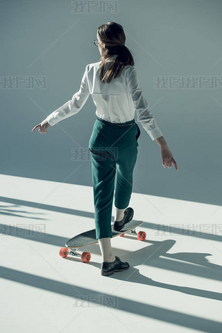 hipster woman standing on skateboard