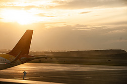 夕阳下飞机站在飞机下的工作人员剪影