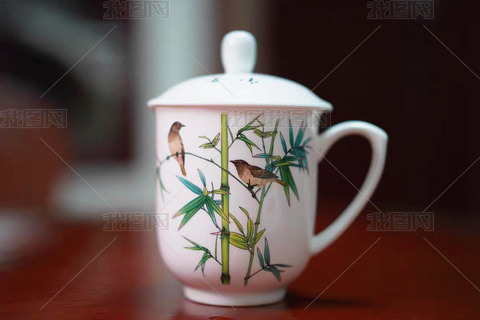 桌面上摆放着一个有竹子图案的茶杯