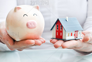 Hands with piggy bank and house model