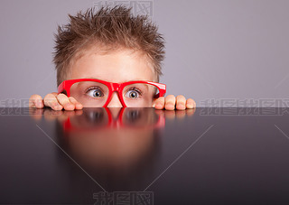 cute boy hiding behind a table