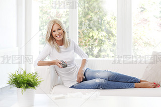 female holding remote controll and watching tv