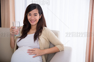 Pregnant asian woman drinking a glass of water