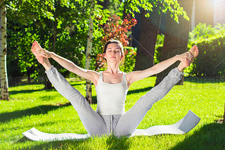 Young woman doing yoga in the park in the morning