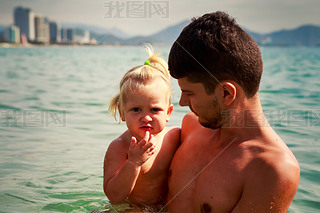 european young father holds iling little daughter in shallow s