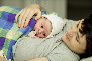 happy woman after birth with a newborn baby